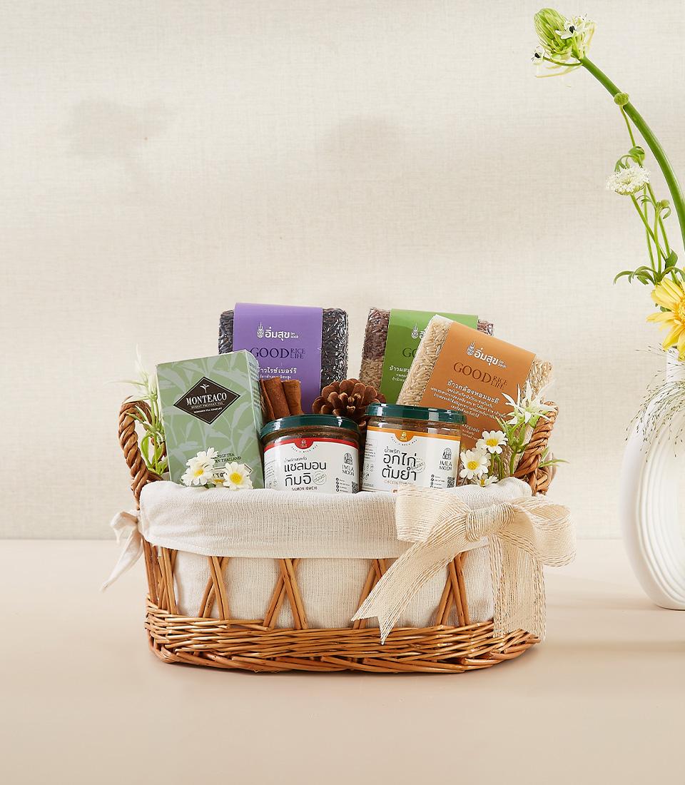 Woven wicker wellness basket with organic rice varieties, herbal tea, artisan spreads, and fresh florals