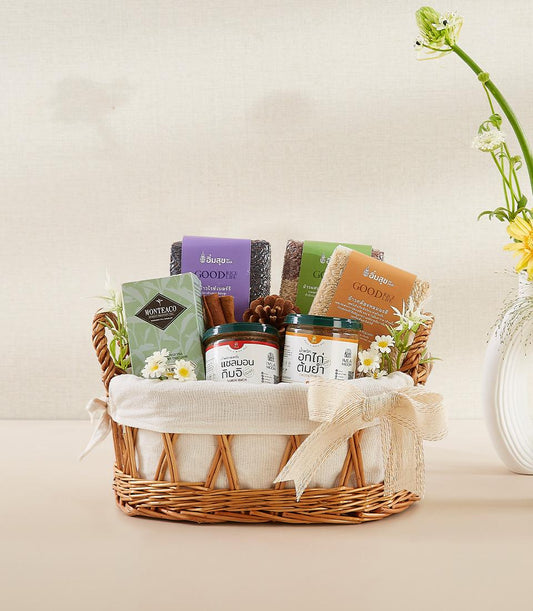 Woven wicker wellness basket with organic rice varieties, herbal tea, artisan spreads, and fresh florals