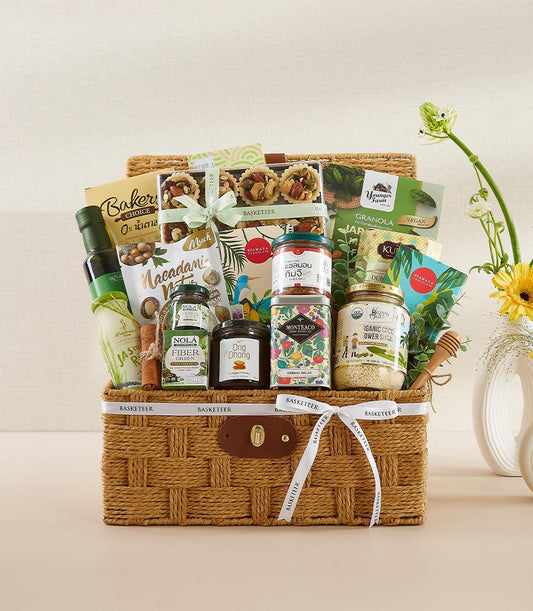 Woven gourmet organic gift basket with olive oil, macadamia nuts, herbal tea, and artisan foods in glass jars