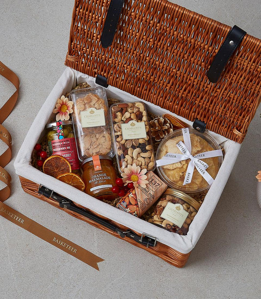 Premium gourmet picnic basket with nuts, marmalade, olives, and dried fruit in wicker hamper