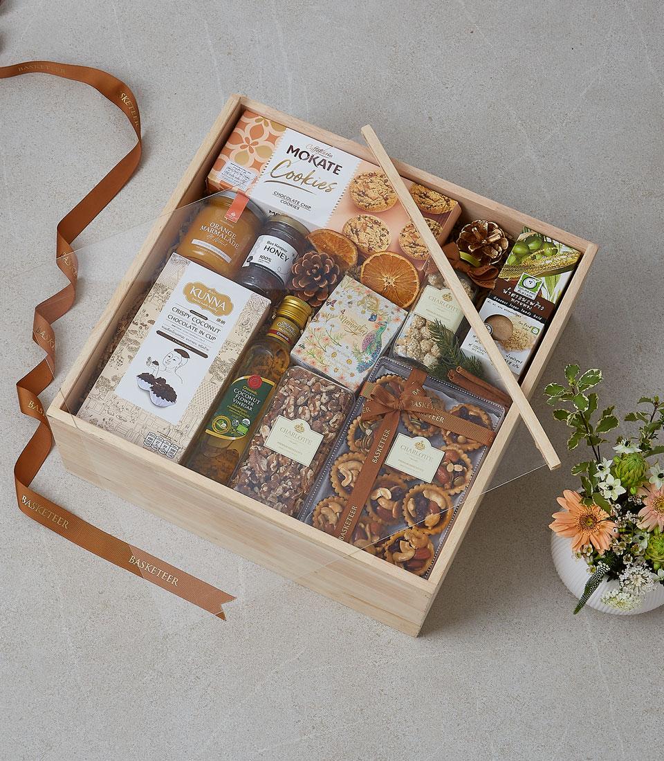 Luxury wooden gift box with gourmet selections, honey, marmalade, cookies, and fresh flowers
