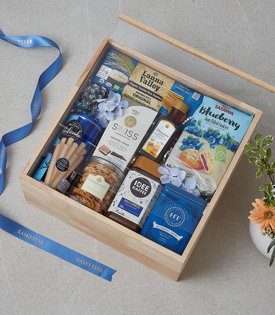 Wooden gift box filled with gourmet snacks, coffee, tea, cookies, and jam—premium holiday cheer hamper