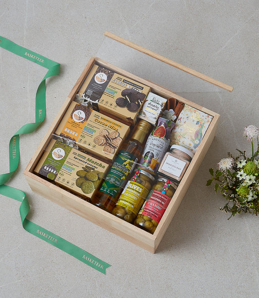 Wooden gift box filled with gourmet cookies, artisan oils, olives, and figs for premium gifting