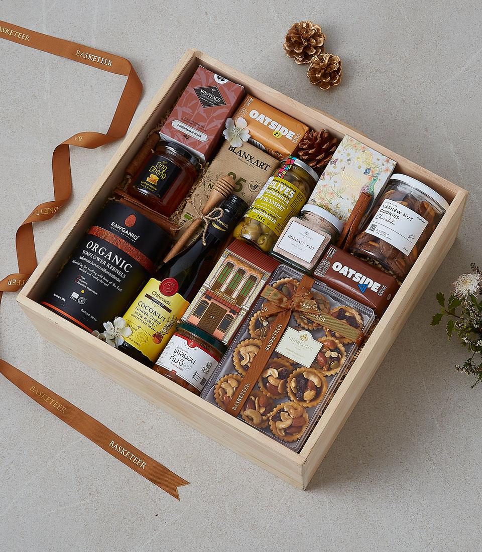 Wooden luxury gift box with gourmet honey, tea, organic kernels, olives, crackers, and artisan cookies