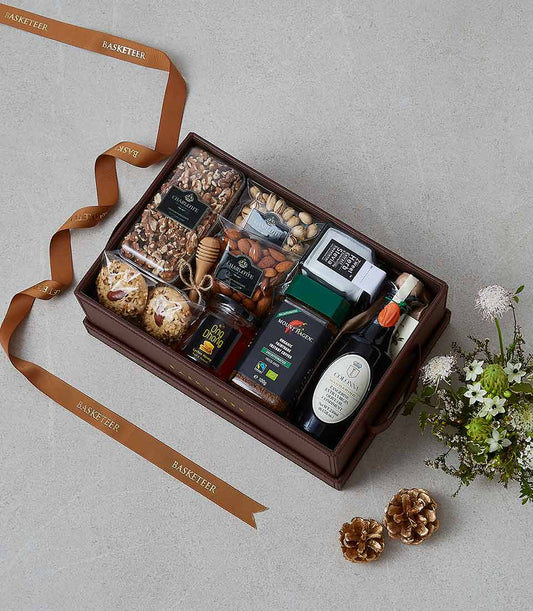 Luxury gourmet gift hamper with nuts, honey, coffee, tea, and olive oil in brown leather box