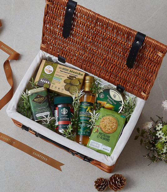 Pistachio and matcha gourmet gift hamper in wicker basket with cookies, tea, coffee, and artisan treats