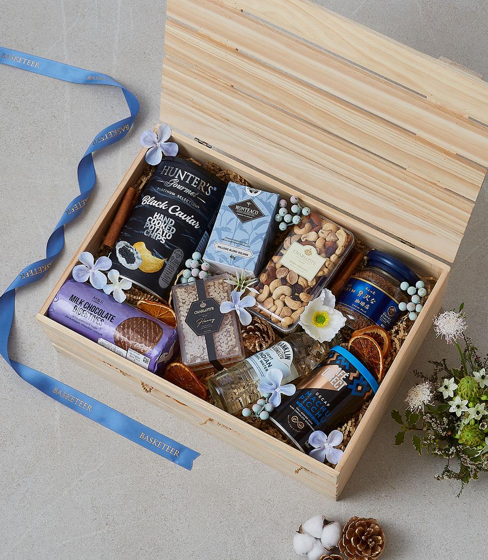 Luxury wooden gourmet gift hamper with caviar crisps, specialty tea, coffee, chocolate, and gourmet treats