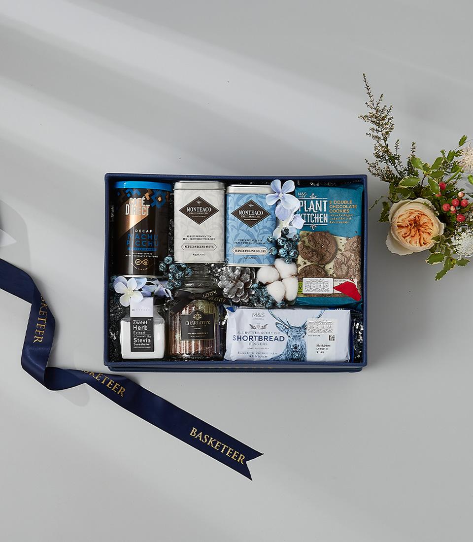 Navy blue New Year gift box with gourmet coffee, tea, Charlotte cookies, shortbread, and fresh winter florals