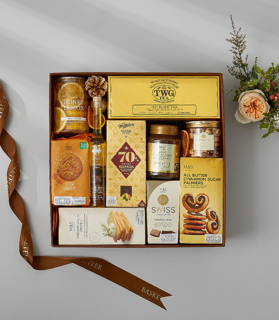 Golden honey, coffee, and gourmet treats luxury gift hamper with fresh flowers and silk ribbon