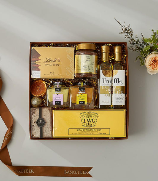 Luxury gourmet gift hamper with Swiss chocolate, truffle oil, Italian spreads, and premium tea in dark brown leather basket