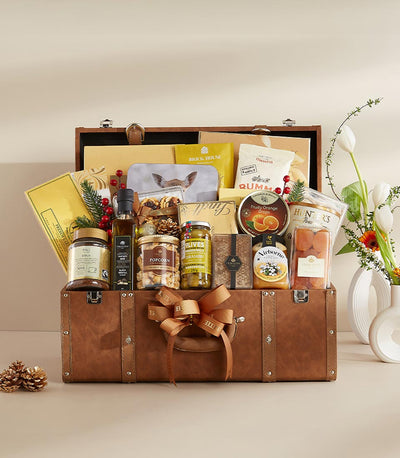 Luxury leather trunk gift hamper with gourmet foods, chocolates, and fresh white tulips
