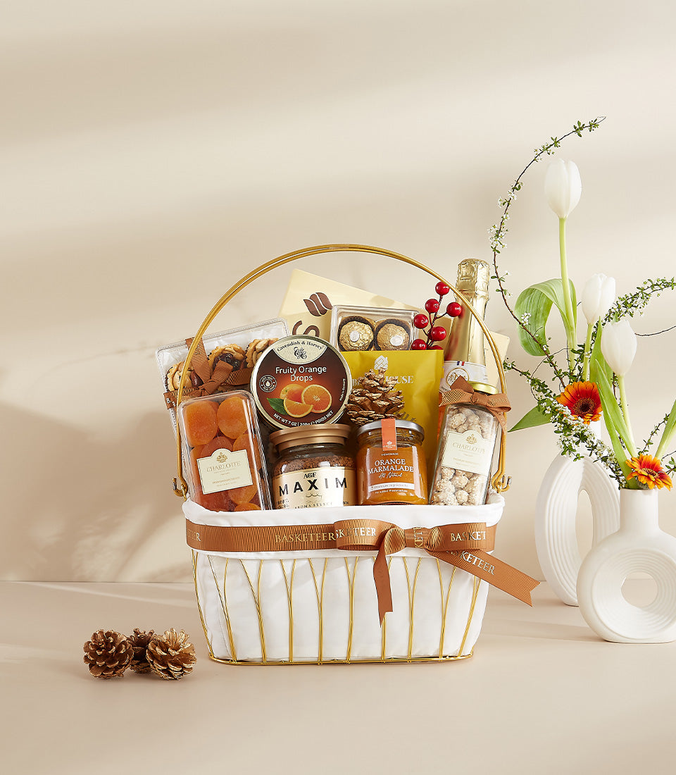 Premium gourmet gift basket with chocolates, coffee, and marmalade, styled with white tulips and festive pinecones for New