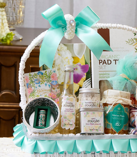 White luxury gift basket with light blue satin bow, Songkran scented essentials, preserves, and organic Thai goods for Thai