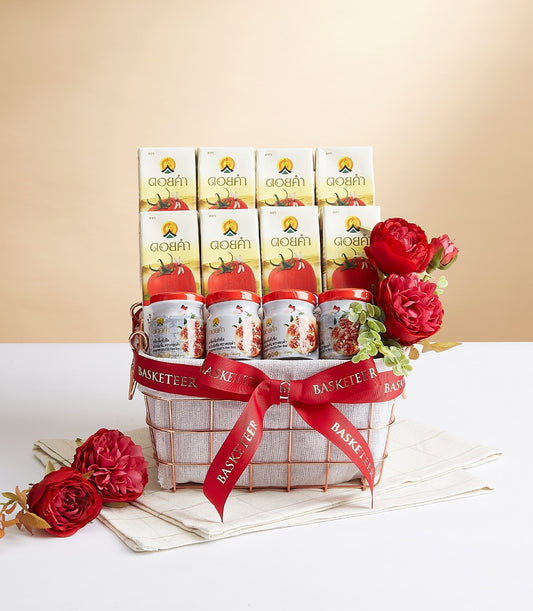 Rose gold wire gift basket with Doi Kham tomato juice cartons, preserve jars, and artificial red peonies