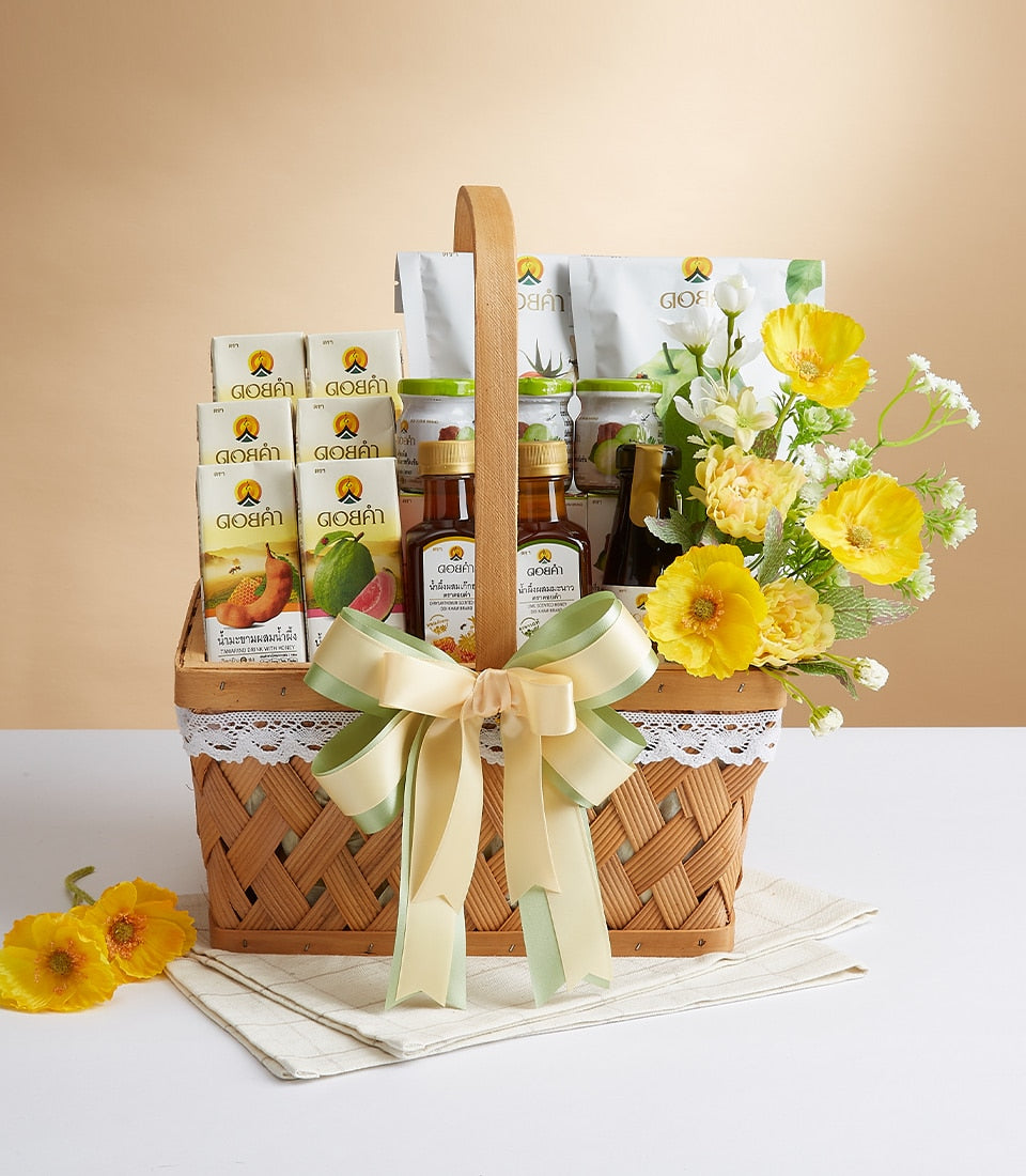 Premium woven gift basket with Doi Kham wellness products, yellow and white flowers, and pale green ribbon bow