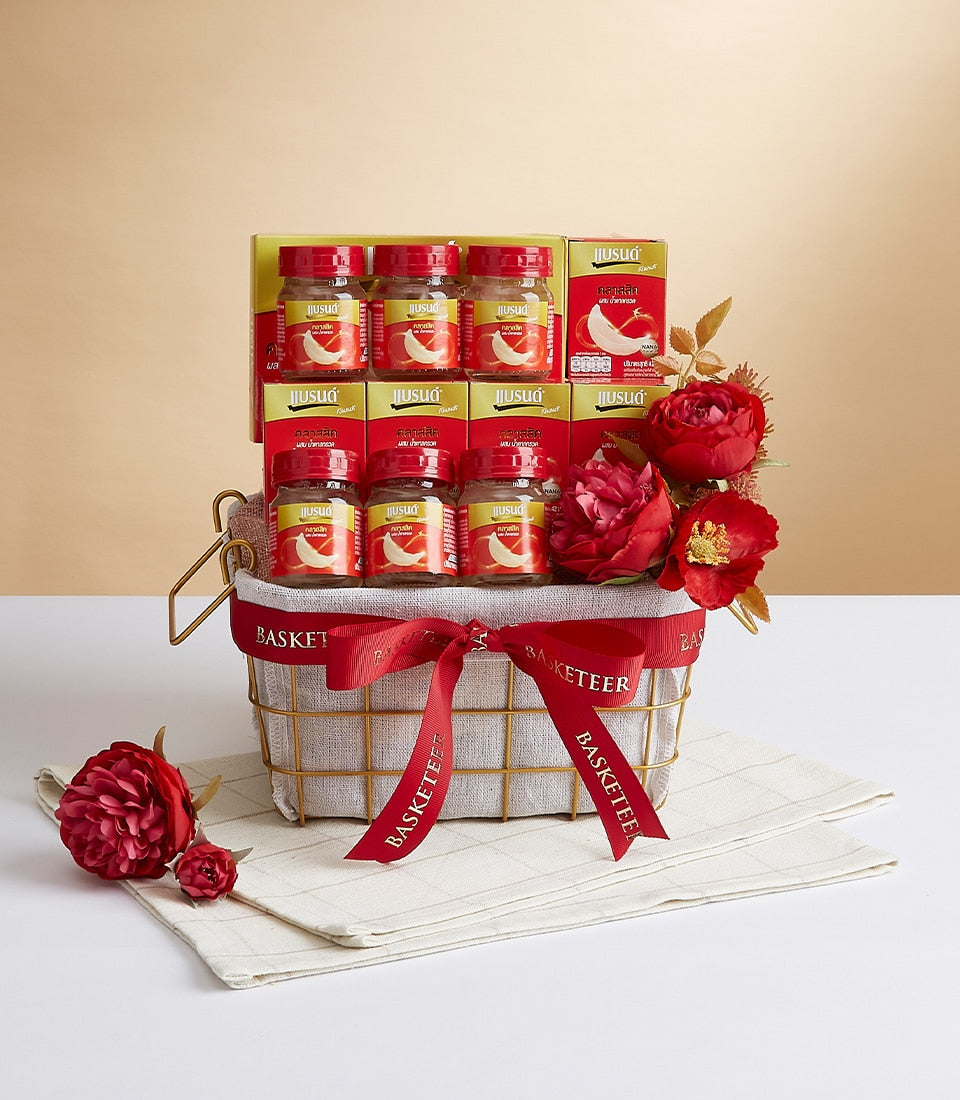 Premium bird's nest health drink gift basket with twelve glass bottles, gold wire basket, red ribbon bow, and festive floral