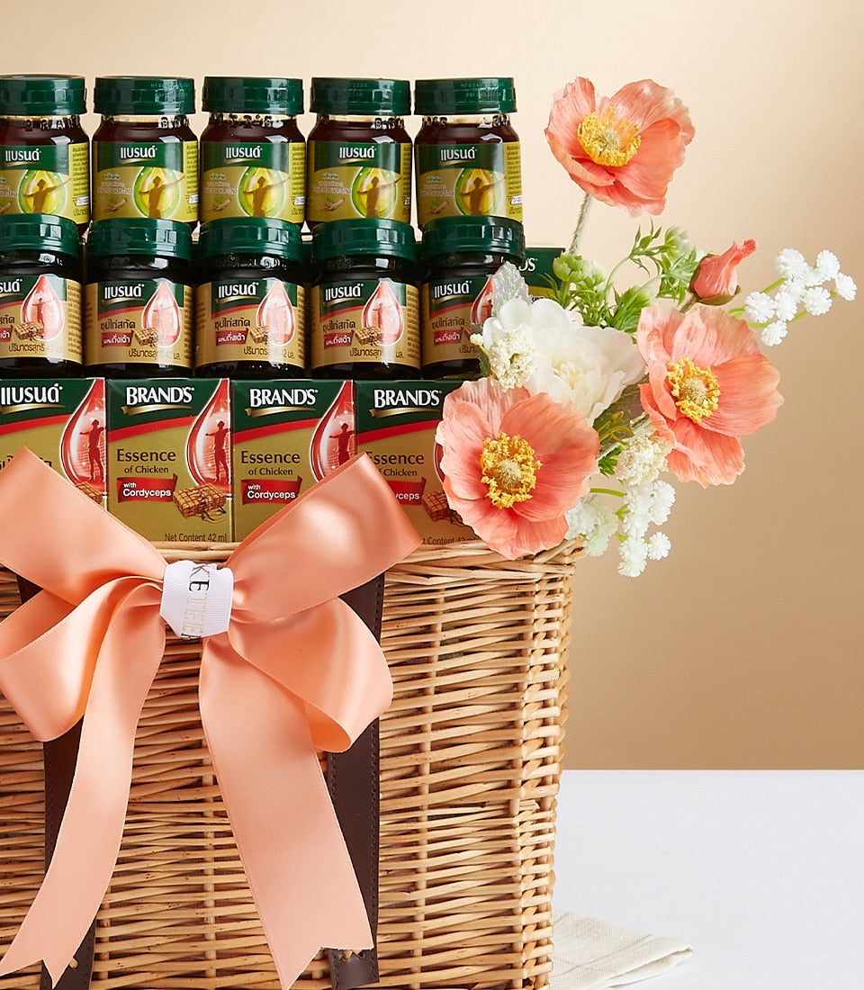 Wicker gift basket with chicken extract soup, health supplements, and peach ribbon bow