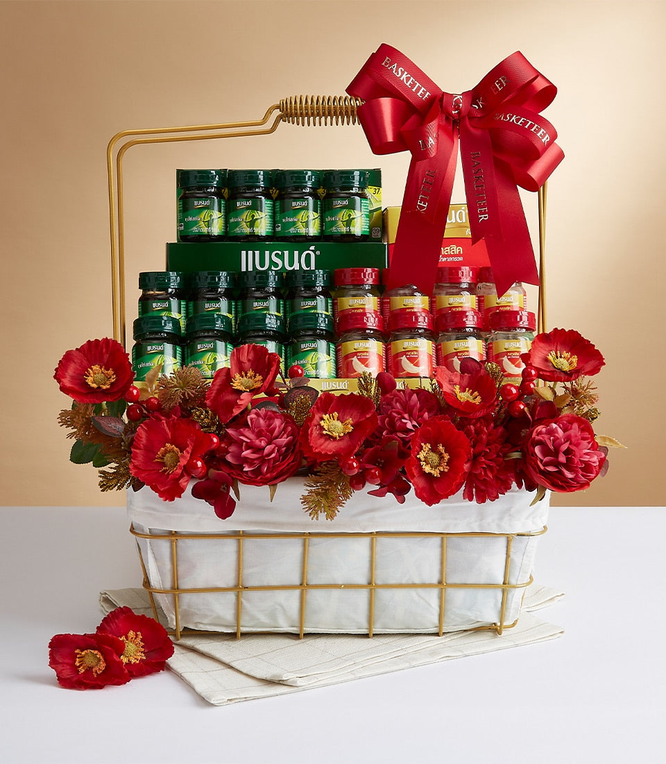 Premium mixed wellness gift basket with glass bottles, red florals, and gold wire frame