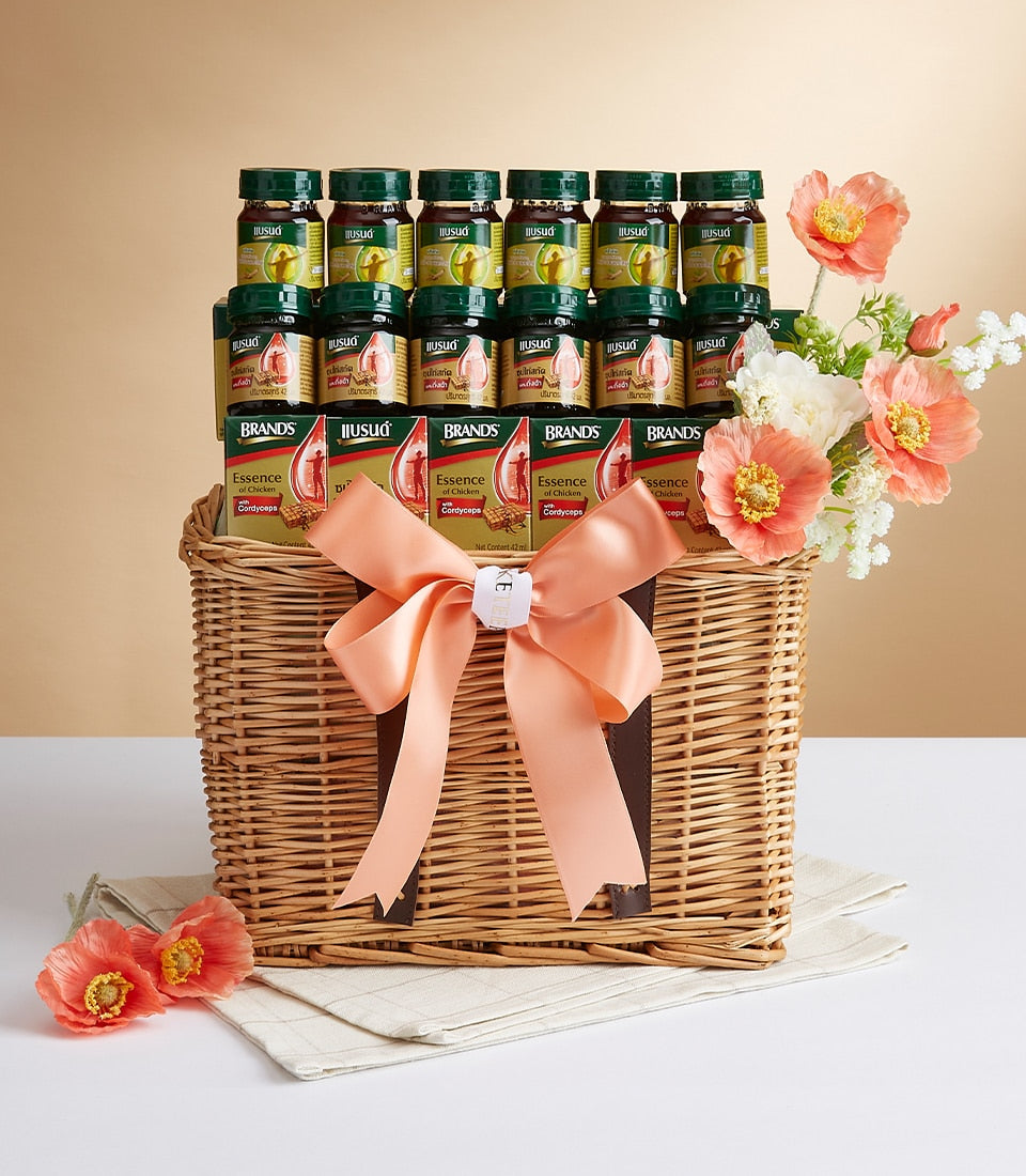 Wicker gift basket with bottled chicken essence and cordyceps health tonics, peach ribbon bow, and artificial flowers