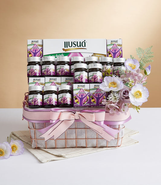 Premium Prune Plus wellness gift basket with glass bottles and rose gold wire basket, pink ribbon bow, and purple-white