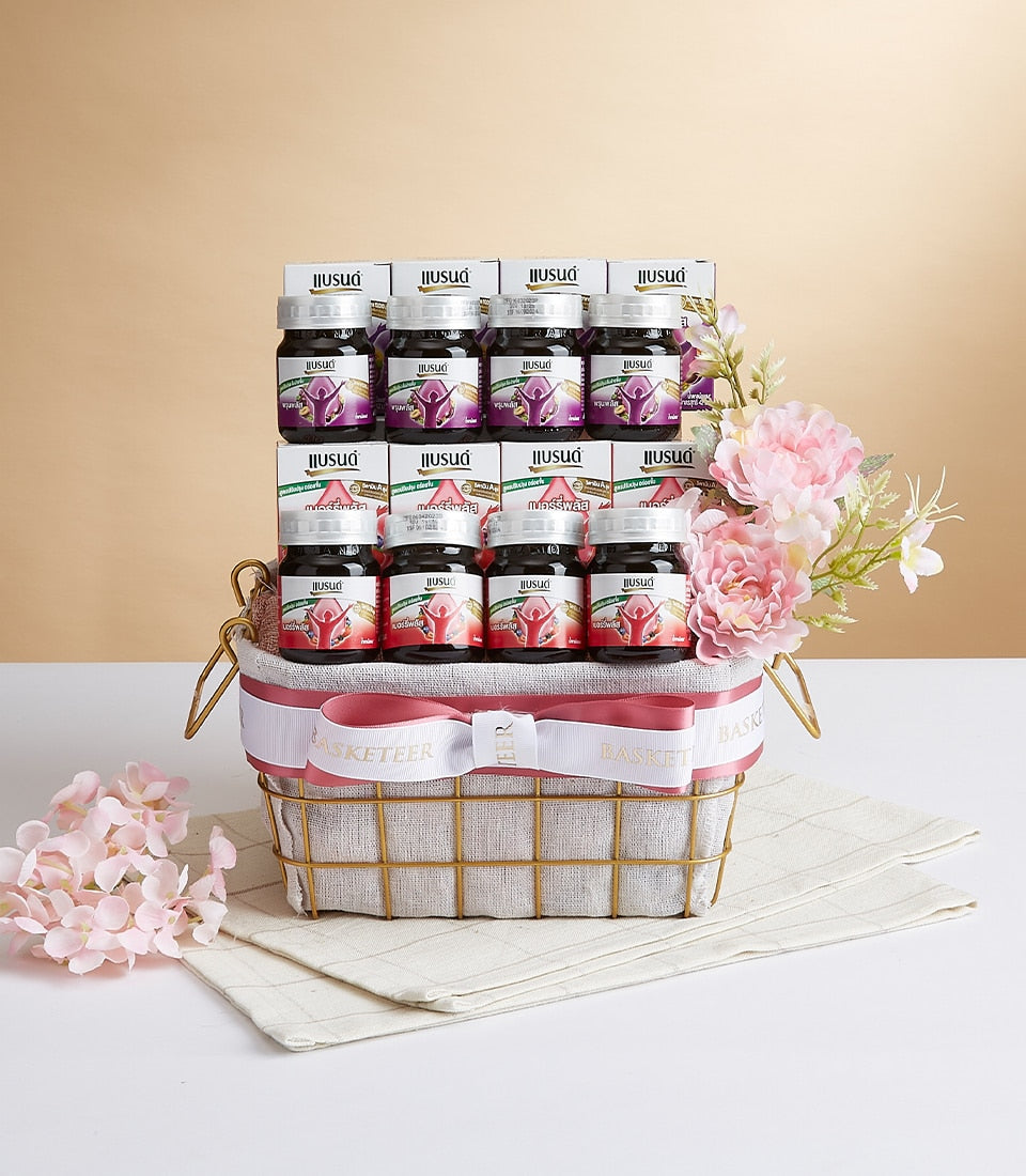 Premium health supplement gift basket with berry and prune wellness bottles in gold wire basket with pink ribbon