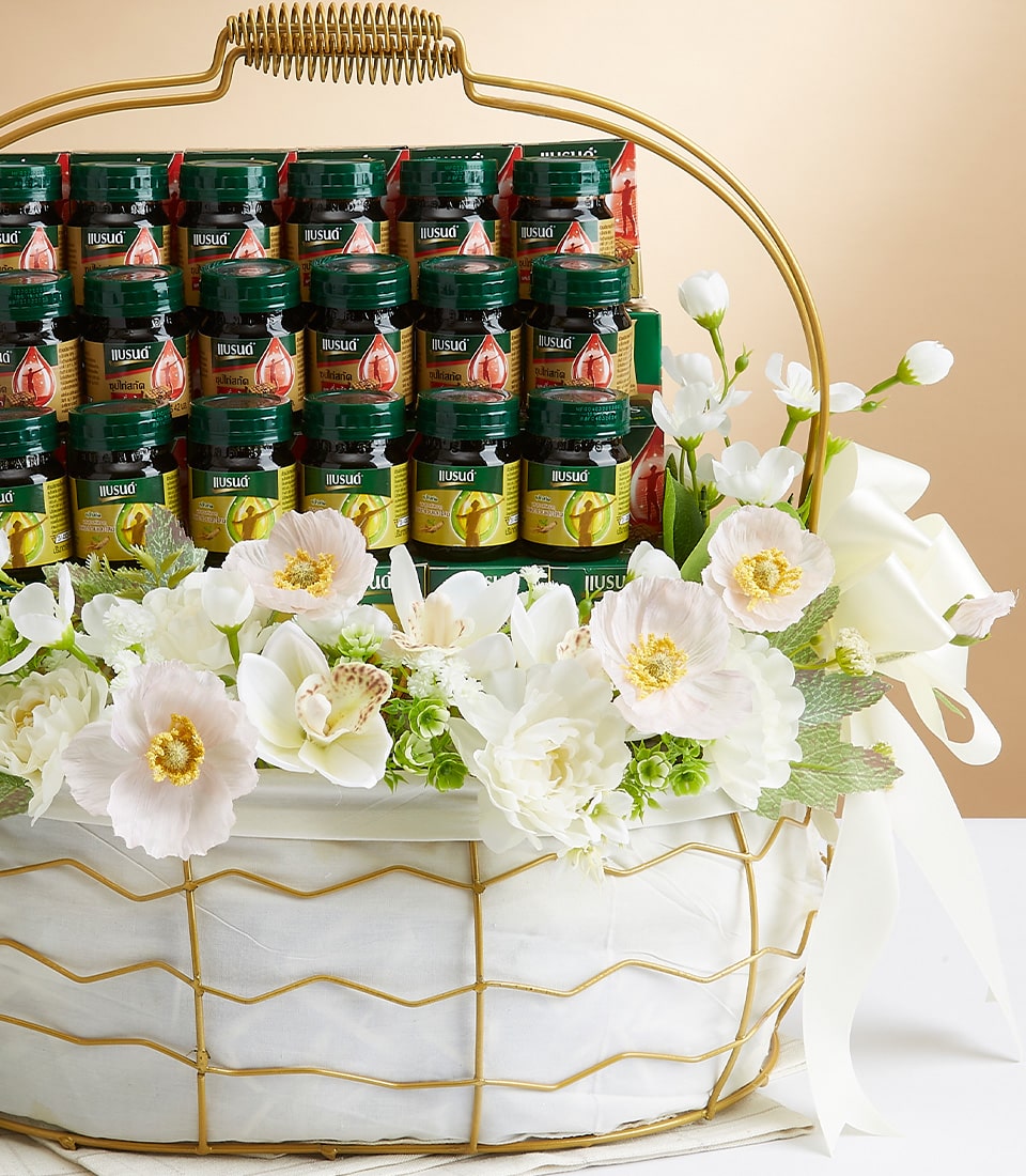 Premium mixed indulgence gift basket with artisan beverages, white poppies, and orchids in gold-trimmed white container