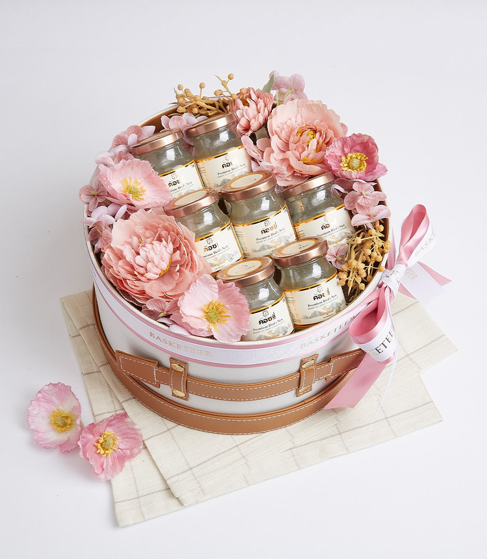 Premium bird's nest gift box with glass jars, pink flowers, and leather straps for luxury gifting