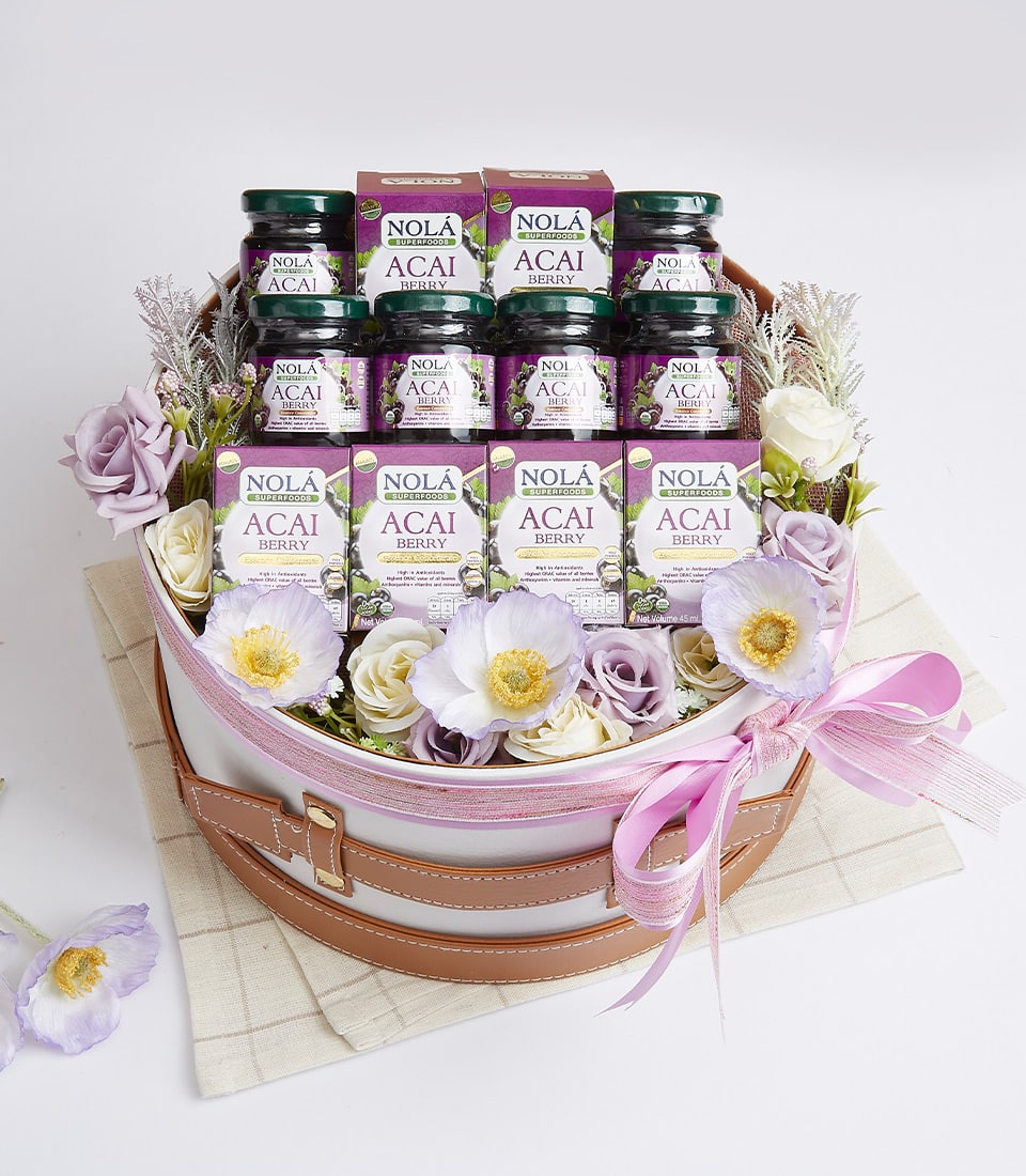 Nola Acai Berry superfood gift basket with purple jars, white woven base, and pink ribbon bow
