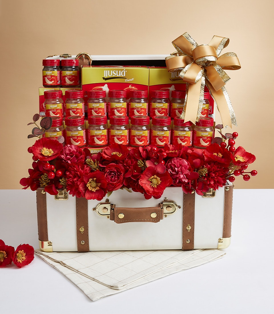 Luxury bird's nest wellness gift hamper in vintage trunk with red flowers and gold ribbon