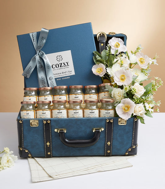 Elegant Essence luxury bird's nest gift set in vintage blue suitcase with twelve premium jars, white flowers, and rose gold