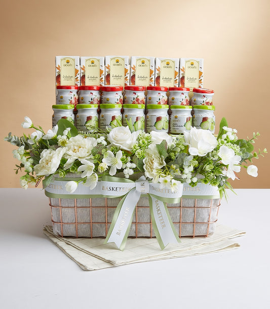 Elevated Doi Kham mixed gift basket with premium Thai preserves, artisan jars, and white floral arrangement