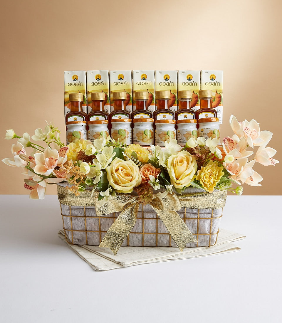 Rectangular grey wire gift basket with gold ribbon bow, cream roses and orchids, seven glass bottles of golden honey or