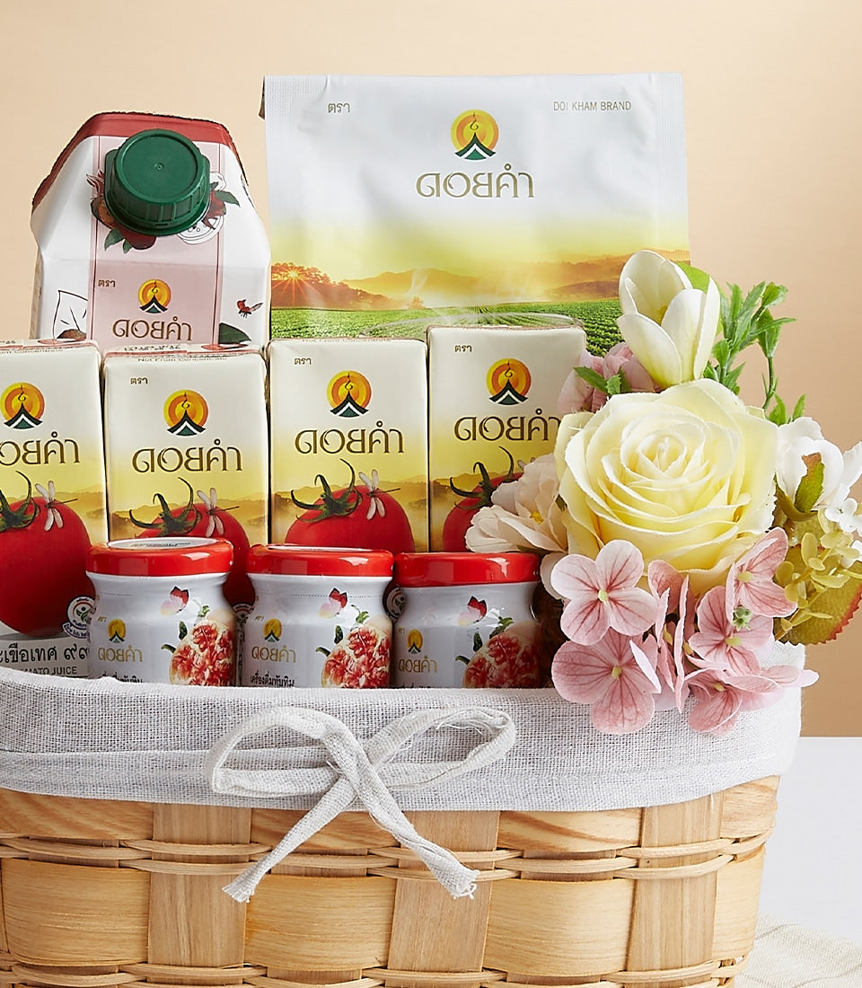 Woven gift basket with Doi Kham wellness products, white packaging, red-lid jars, and cream roses