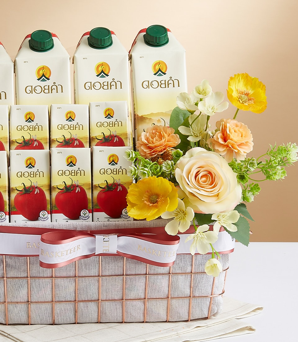 Regal Doi Kham wellness gift basket with rose gold wire frame, white beverage cartons, and fresh orange roses with yellow