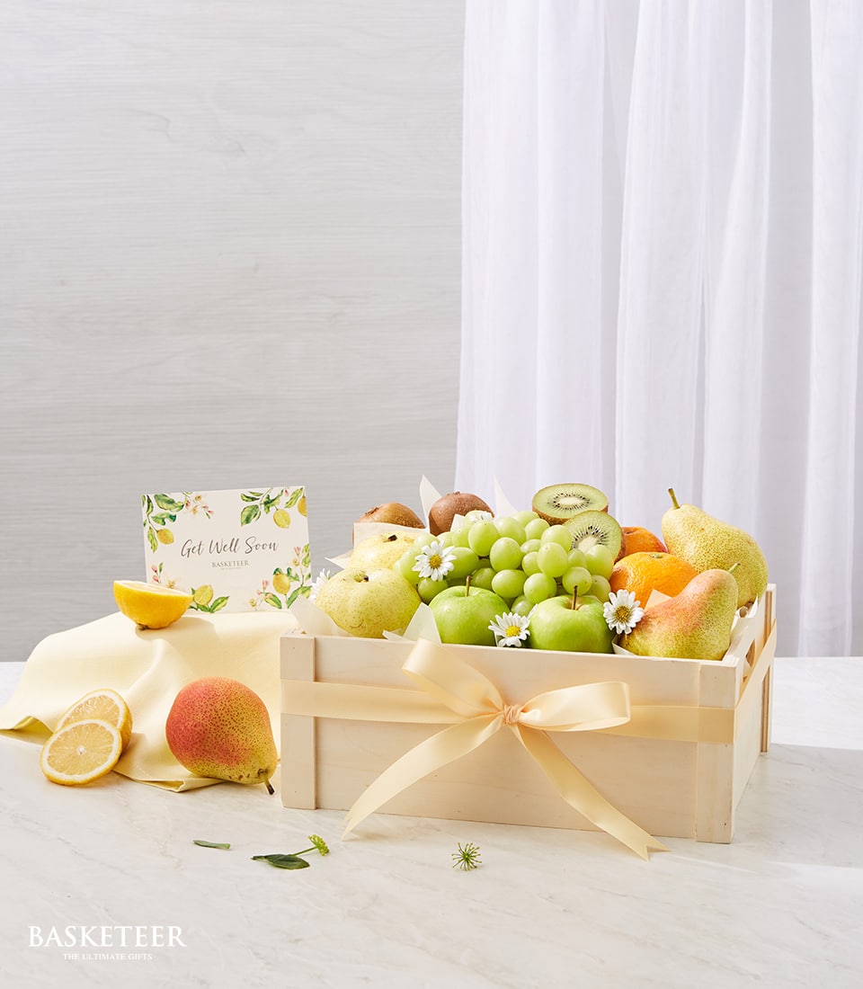 Wooden crate filled with fresh green apples, kiwis, grapes, pears, and oranges tied with pale yellow ribbon, Get Well Soon