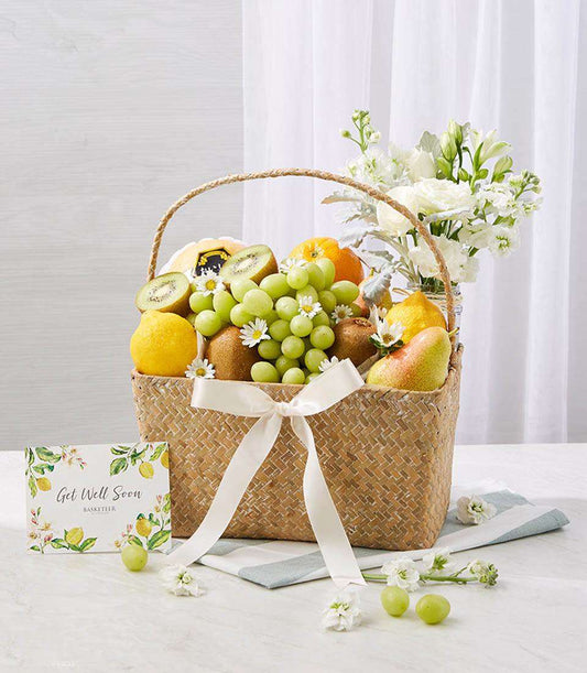 Get well fruit and flower gift basket with fresh grapes, citrus, and white daisies in woven straw