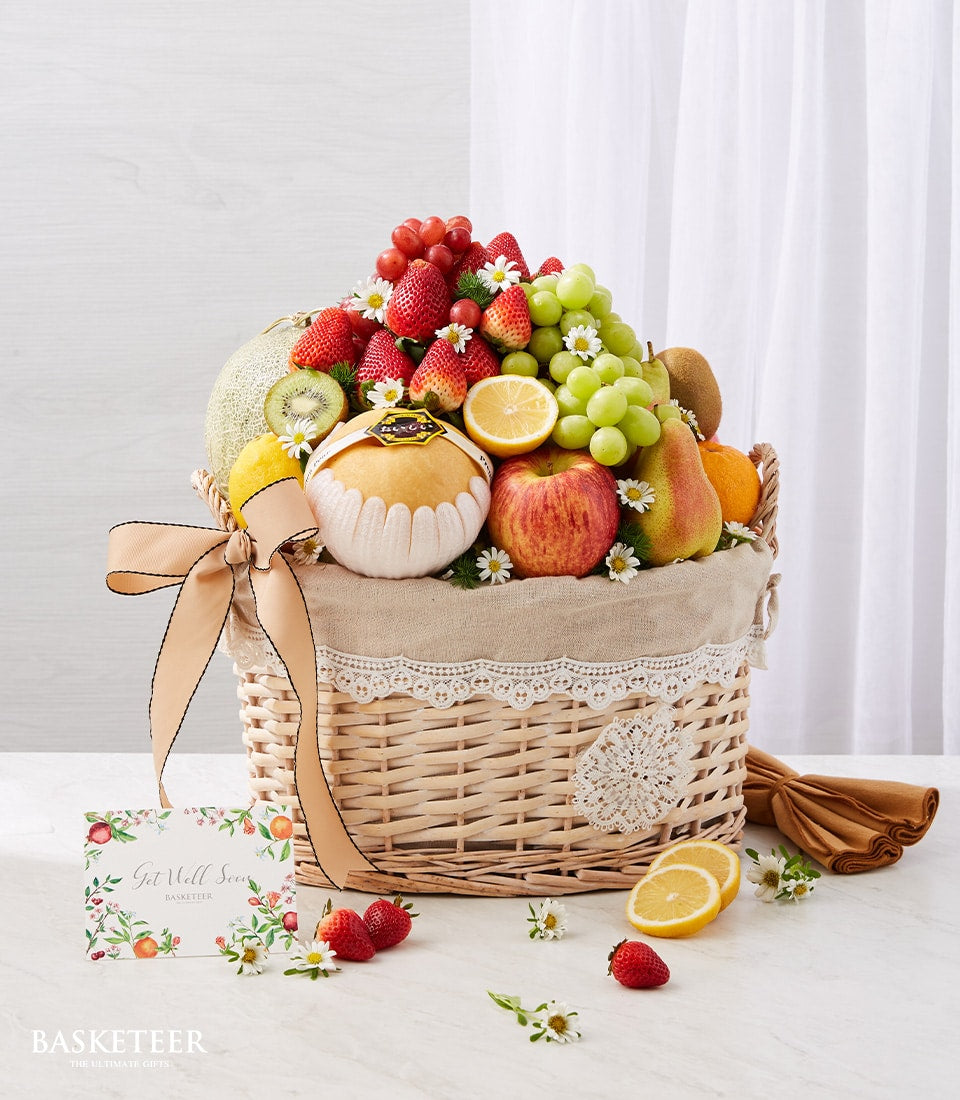 Premium wicker fruit basket with fresh grapes, strawberries, and seasonal produce for get well recovery