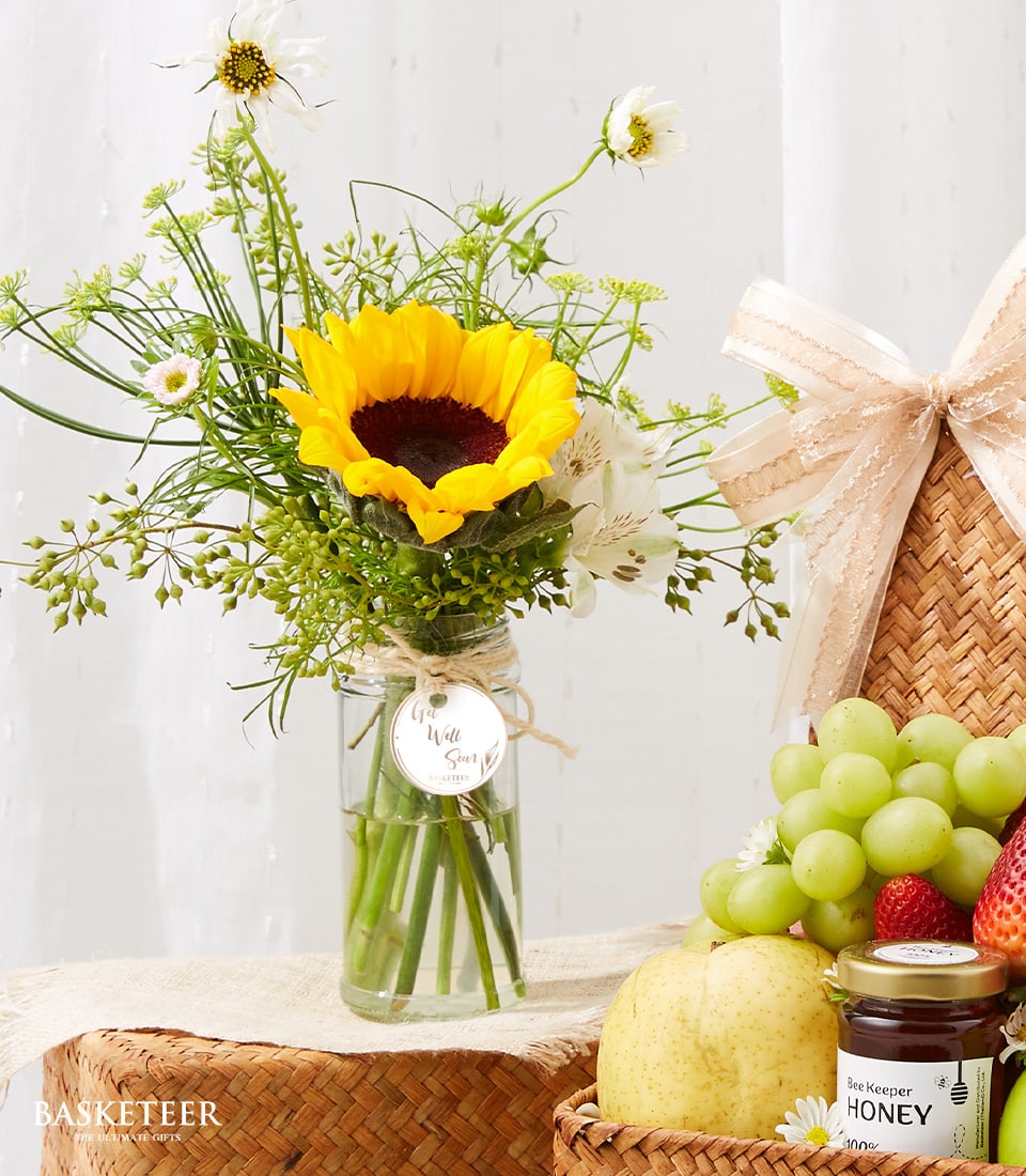 Fresh fruit basket with yellow sunflower bouquet in glass vase, get well gift set