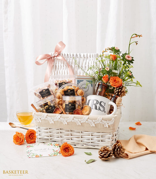 Mixed nuts, tea, and fresh orange roses get well gift basket with Charlotte Bakery treats and blooms