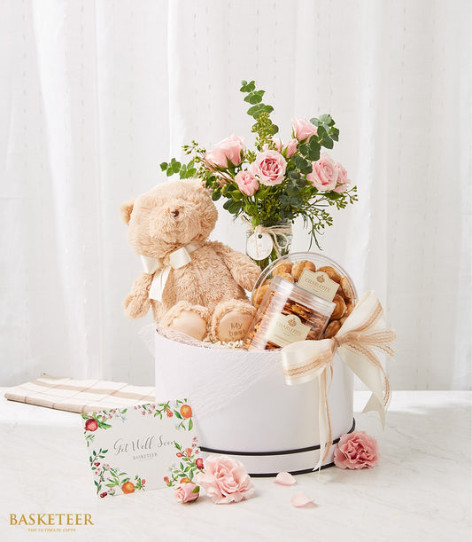 Cream and white gift basket with teddy bear, pink roses, and Charlotte Bakery cookies for get well wishes