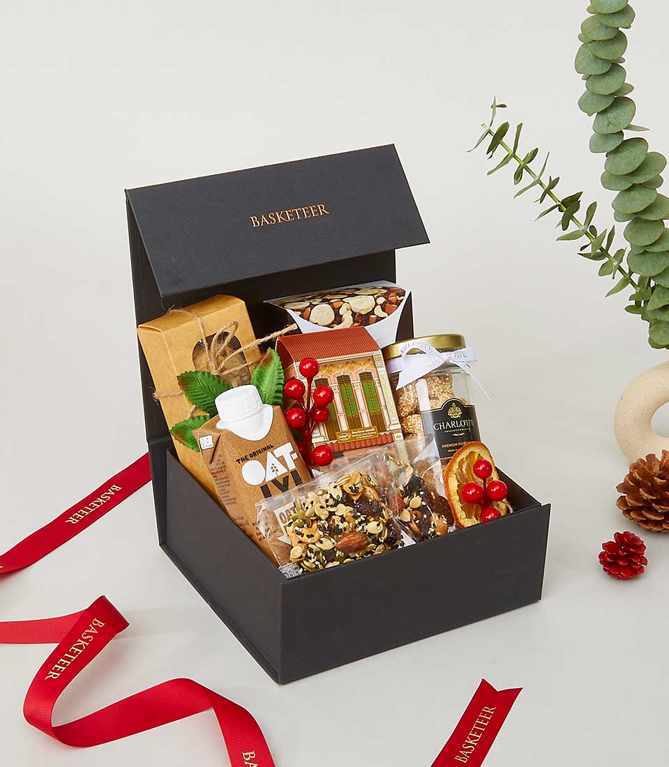 Black wellness snack gift box with oat milk, granola, and gourmet treats, festive New Year hamper