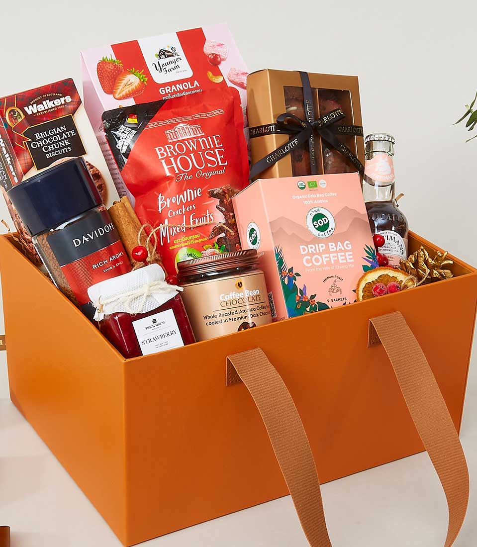 Premium gourmet gift hamper in orange leather carryall with granola, brownies, coffee, and jam for New Year gifting
