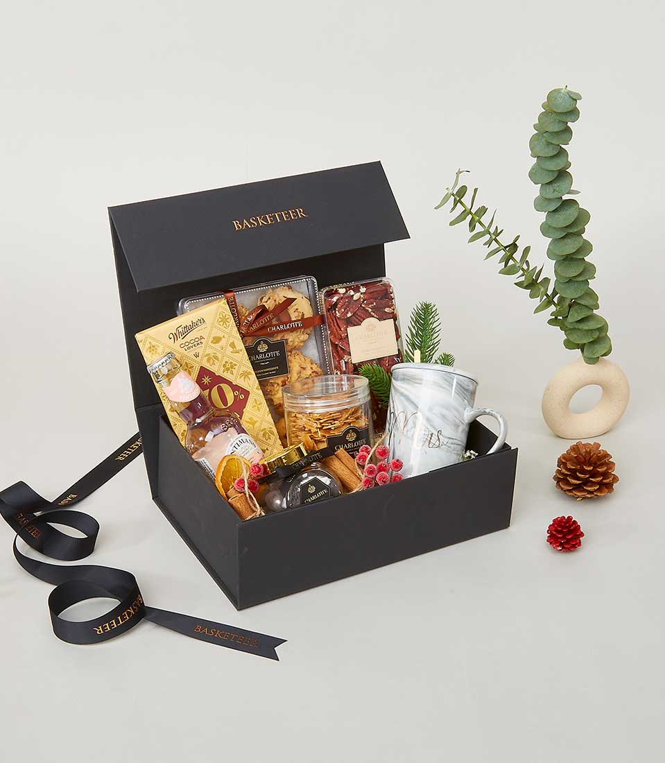 Luxury New Year gift basket with gourmet chocolates, cookies, honey, and marble mug with festive cinnamon and dried citrus