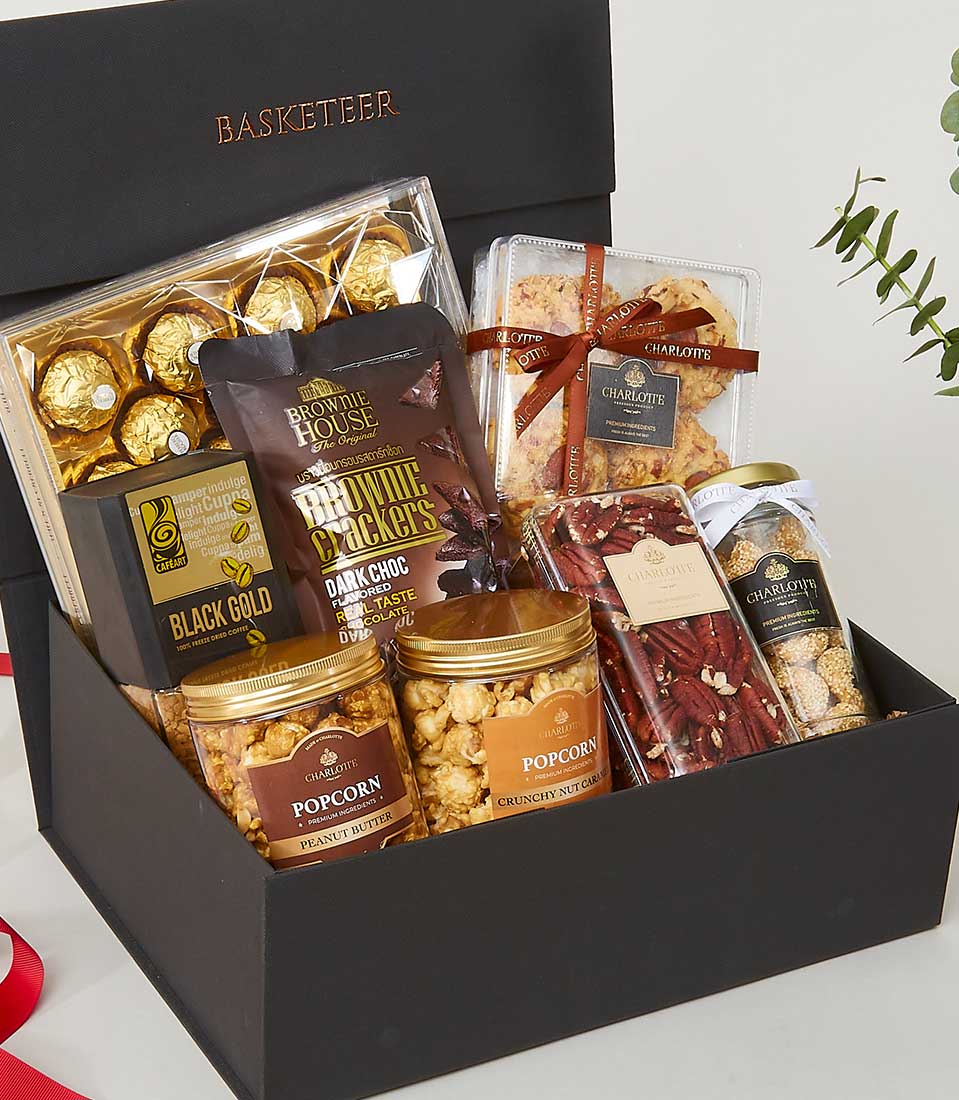 Luxury New Year gift box with gold-wrapped chocolates, brownie crackers, freeze-dried coffee, and gourmet snacks in black