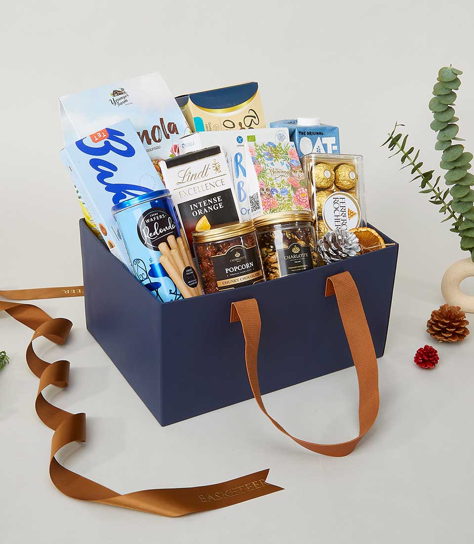Navy leather gift box with gourmet chocolates, wafers, and artisan treats, finished with brown ribbon for New Year gifting