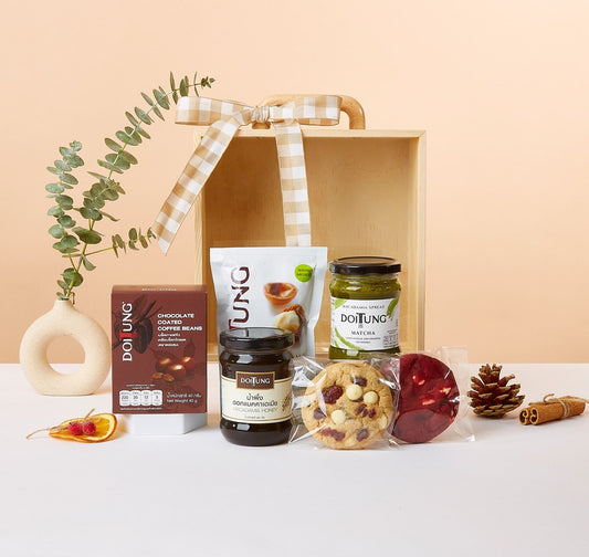 Wellness gift box with macadamia honey, matcha spread, coffee beans, cookies, and eucalyptus in ceramic vase
