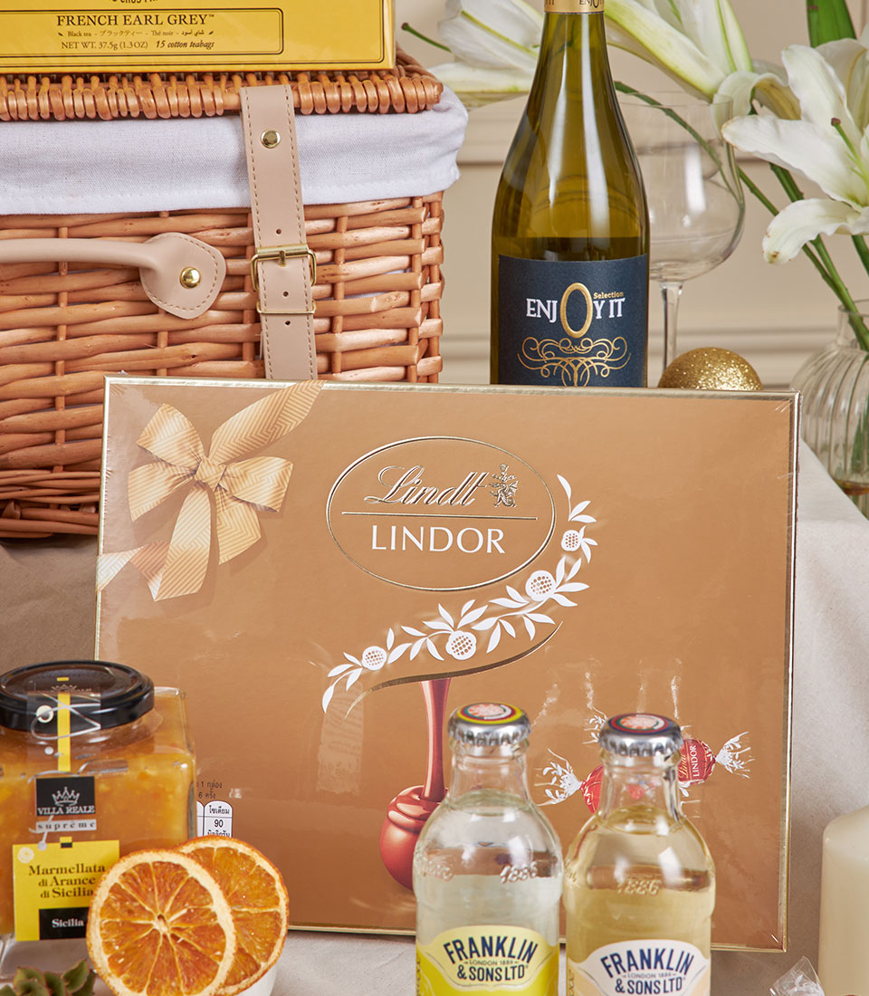 Luxury New Year gift hamper with Lindt chocolates, French tea, white wine, marmalade, and gourmet treats in wicker basket