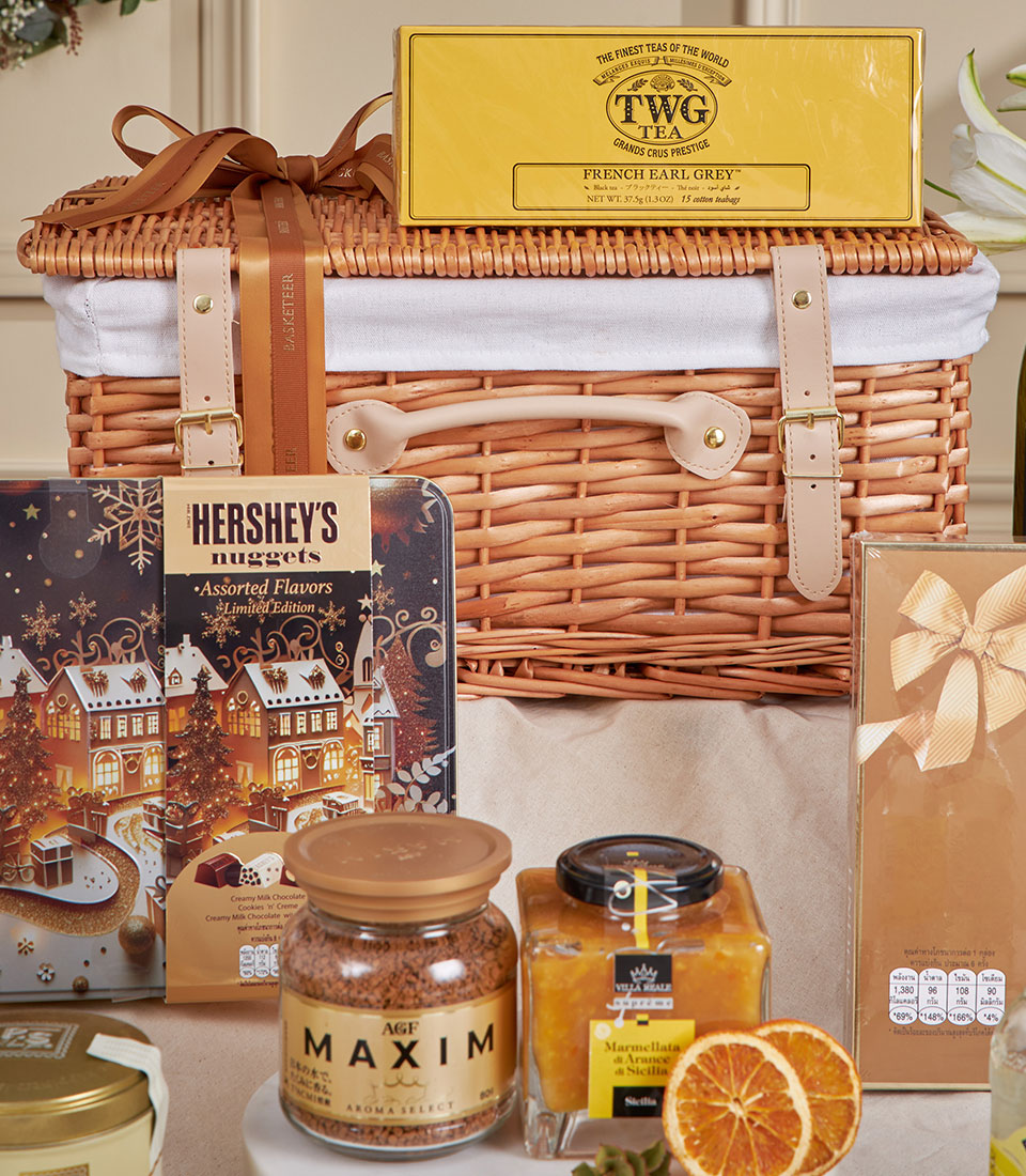 Basketeer luxury gift basket: Earl Grey tea, gourmet marmalade, and chocolates in a wicker hamper with tan ribbon. Premium hamper delivery Thailand.