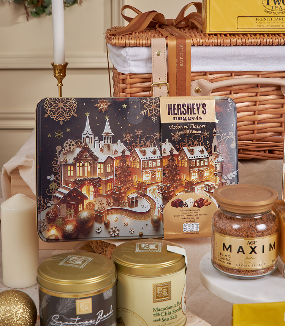 Luxury gourmet celebration hamper with premium chocolates, tea, coffee, and festive gold accents in woven basket