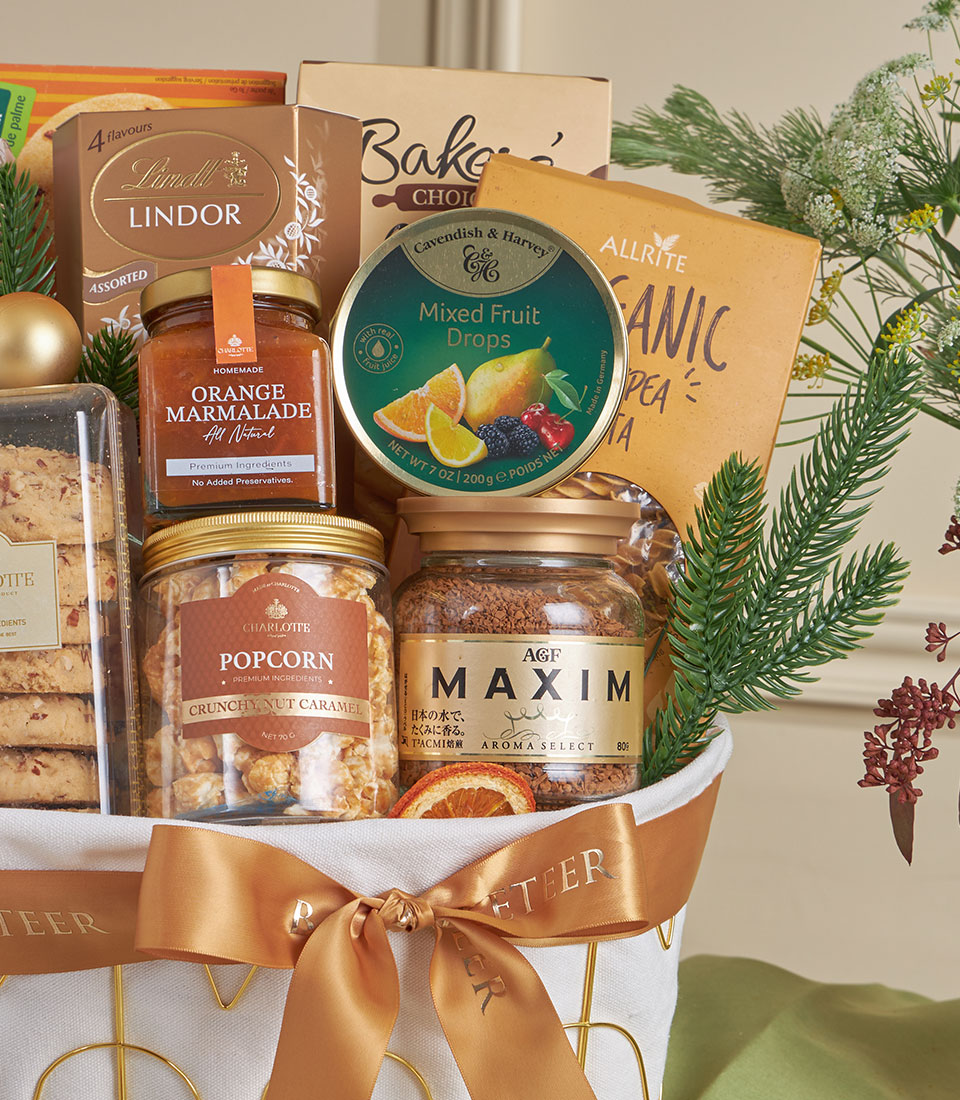 Golden luxury gourmet gift basket with chocolates, marmalade, pasta, and coffee, tied with gold ribbon for New Year